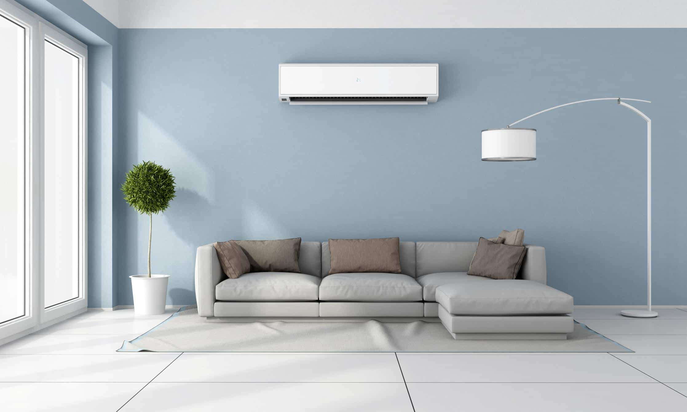 Bright living room with a sectional and ductless heat pump on the wall
