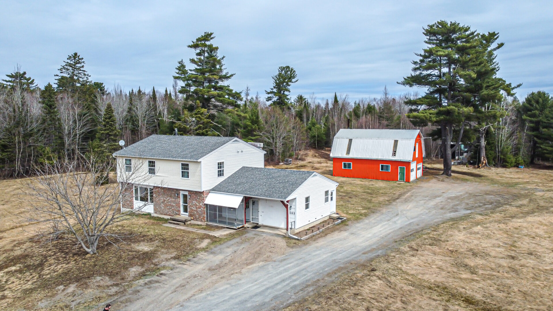 aerial photo of a white two storey home with an orange barn behind it